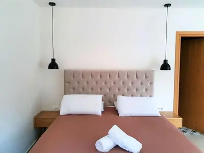 a bedroom with a large bed with two white pillows at Galini View Apartments Lindos in Líndos