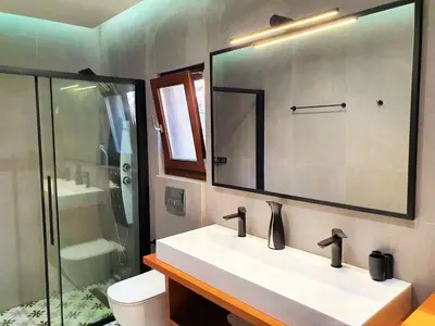 a bathroom with a sink and a toilet and a mirror at Galini View Apartments Lindos in Líndos
