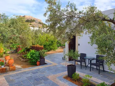 a patio with a table and chairs and trees at Galini View Apartments Lindos in Líndos