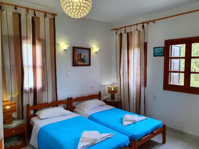 a bedroom with two beds and a window at Galini View Apartments Lindos in Líndos