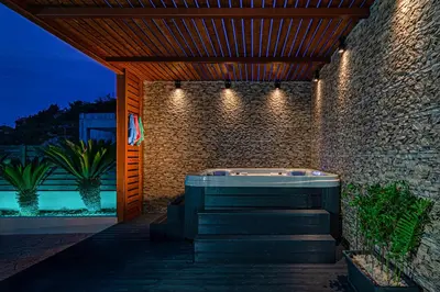a jacuzzi tub on a brick wall with lights at Maria's Luxurious Villa in Koskinou in Koskinou