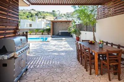 a patio with a wooden table and a stove at Maria's Luxurious Villa in Koskinou in Koskinou