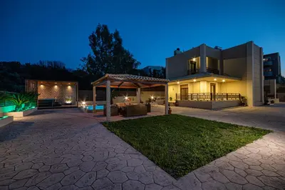 a large house with a backyard at night at Maria's Luxurious Villa in Koskinou in Koskinou