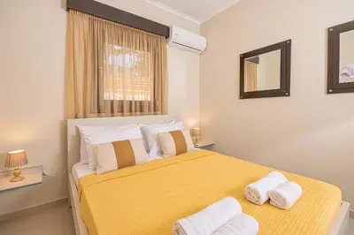 a bedroom with a yellow bed with towels on it at Maria's Luxurious Villa in Koskinou in Koskinou