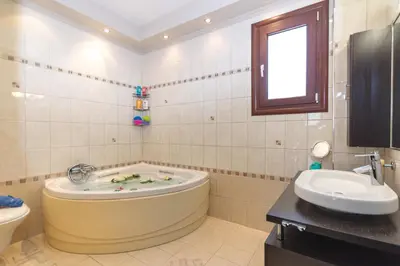 a bathroom with a tub and a sink at Maria's Luxurious Villa in Koskinou in Koskinou