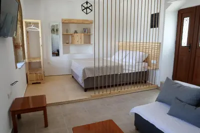 a bedroom with a bed and a couch in a room at Heliophilia Lindos in Líndos