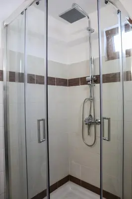 a shower with a glass door in a bathroom at Heliophilia Lindos in Líndos