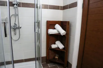 a towel rack in a bathroom with white towels at Heliophilia Lindos in Líndos
