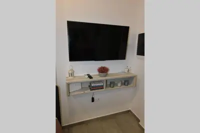 a living room with a television on a wall at Lolos' house in Rhodes Town