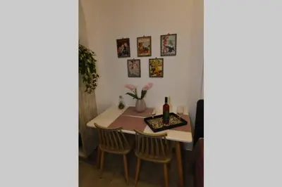 a dining room table with two chairs and a bottle of wine at Lolos' house in Rhodes Town