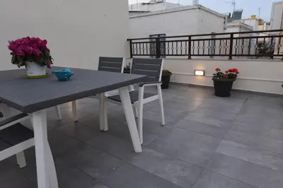a table and chairs on a balcony with flowers at Lolos' house in Rhodes Town