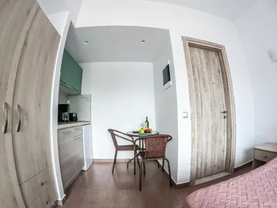 a small kitchen and a table in a room at Red Hibiscus Stegna in Archangelos