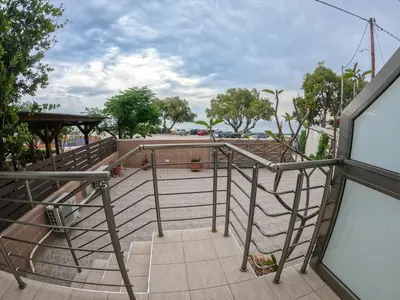 a balcony with a metal railing and a view of the ocean at Red Hibiscus Stegna in Archangelos