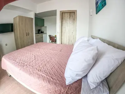 a bedroom with a bed with pink sheets and white pillows at Red Hibiscus Stegna in Archangelos