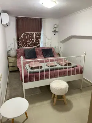 a bedroom with a white bed with a pink comforter at Casa Fiore, Rhodes in Rhodes Town