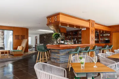 a restaurant with tables and chairs and a bar at LINDOS GARDENS RESORT COMPLEX in Líndos