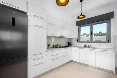 a kitchen with white cabinets and a window at Wonderview Exclusive Apartment in Kremasti