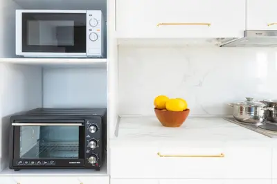 a kitchen with a microwave and a bowl of oranges at Wonderview Exclusive Apartment in Kremasti