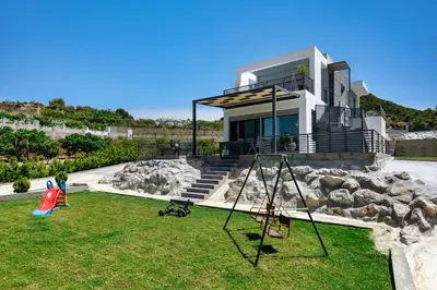a house with a yard with a playground at Wonderview Exclusive Apartment in Kremasti