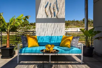 a blue couch on a balcony with a table at Wonderview Exclusive Apartment in Kremasti