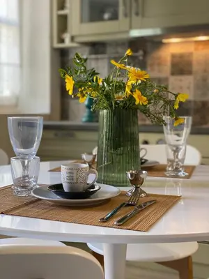 a table with a vase of yellow flowers on a table at LUCA'S HOUSES in Halki