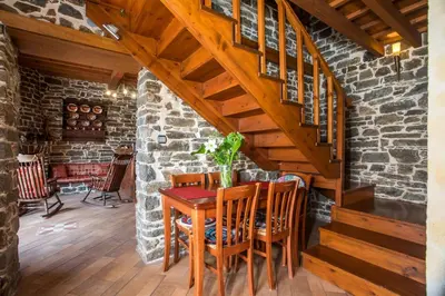 a dining room with a wooden table and stairs at Echo Traditional House - Ηχώ Παραδοσιακό Σπίτι in Émbonas