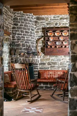 two rocking chairs in front of a stone fireplace at Echo Traditional House - Ηχώ Παραδοσιακό Σπίτι in Émbonas