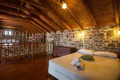 a bedroom with a bed in a stone wall at Echo Traditional House - Ηχώ Παραδοσιακό Σπίτι in Émbonas