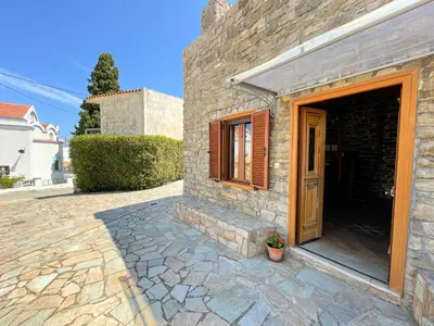 a stone building with a door and a patio at Echo Traditional House - Ηχώ Παραδοσιακό Σπίτι in Émbonas
