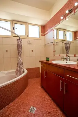 a bathroom with a tub and a sink and a mirror at Pegasus Villa in Ialyssos