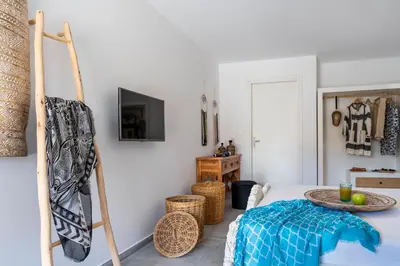 a room with a bed with a table and a tv at Onar Villa Kolympia in Kolimbia