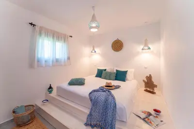 a bedroom with a white bed with a hat on it at Onar Villa Kolympia in Kolimbia