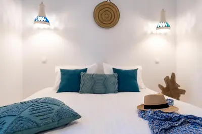 a bedroom with a bed with a hat on it at Onar Villa Kolympia in Kolimbia