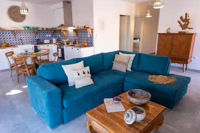 a living room with a blue couch and a table at Onar Villa Kolympia in Kolimbia