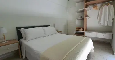 a bedroom with a white bed and a closet at Rodos Beach Apartment 33 in Rhodes Town