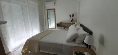 a bedroom with a bed with white pillows and a window at Rodos Beach Apartment 33 in Rhodes Town