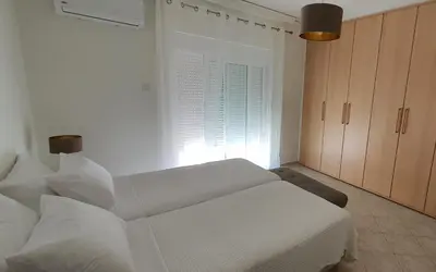a white room with a bed and a window at Rodos Beach Apartment 33 in Rhodes Town