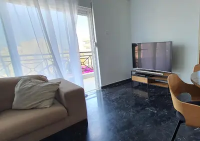 a living room with a couch and a flat screen tv at Rodos Beach Apartment 33 in Rhodes Town