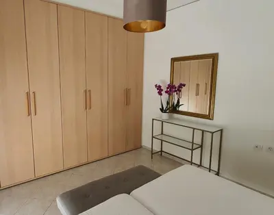 a living room with a couch and a mirror at Rodos Beach Apartment 33 in Rhodes Town