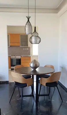 a dining room table with two chairs and two pendant lights at Rodos Beach Apartment 33 in Rhodes Town