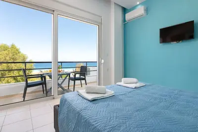 a bedroom with a bed and a view of the ocean at Rhodes Sea Ialysos Apartment in Ialyssos