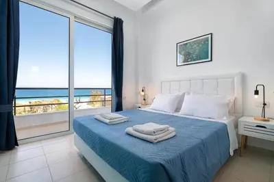 a bedroom with a bed with a view of the ocean at Rhodes Sea Ialysos Apartment in Ialyssos