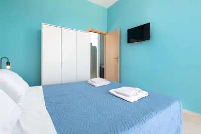 a blue room with a bed with two towels on it at Rhodes Sea Ialysos Apartment in Ialyssos
