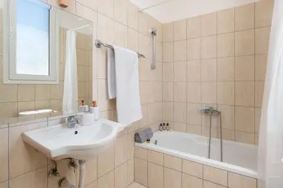 a bathroom with a sink and a bath tub at Rhodes Sea Ialysos Apartment in Ialyssos