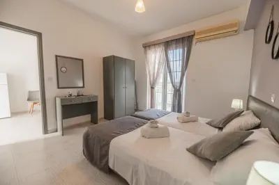 a bedroom with two beds and a desk and a window at Rhodes Archaggelos Retreat-Nest Among Garden in Archangelos