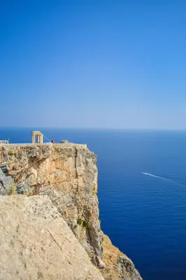a building on top of a cliff next to the ocean at Rhodes Archaggelos Retreat-Nest Among Garden in Archangelos