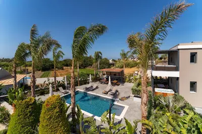 an aerial view of a resort with a swimming pool and palm trees at Palmeral Luxury Suites in Rhodes Town