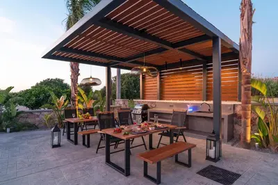 a patio with tables and chairs under a pergola at Palmeral Luxury Suites in Rhodes Town