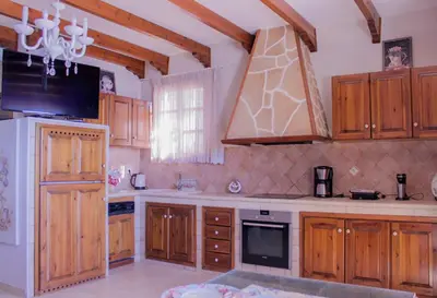 a kitchen with wooden cabinets and a stove top oven at Villa Limnioni in Archangelos