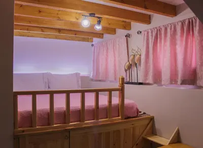 a bedroom with a bed and pink curtains at Villa Limnioni in Archangelos